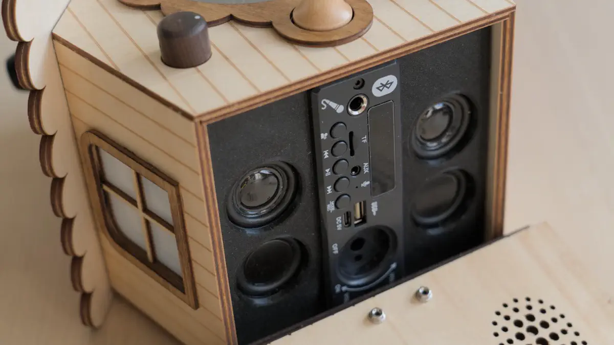 Onderkant van vogelhuisje met audiospeler en luidsprekers zichtbaar